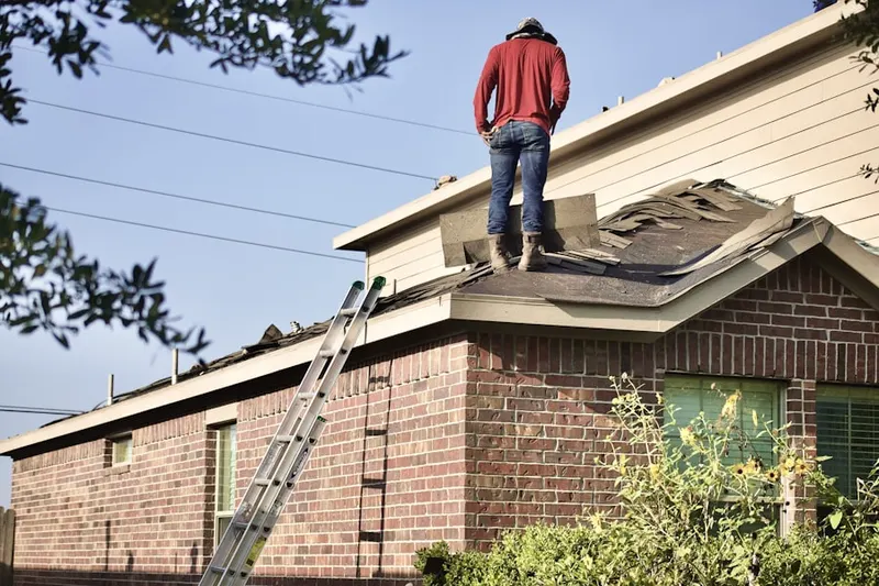 Professional roofer working on a residential roof in Sheeder